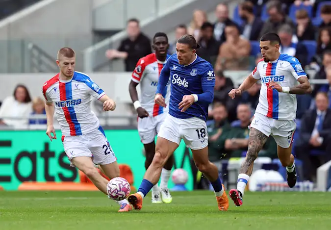 Adam Wharton and Daniel Munoz of Crystal Palace try to rob Everton's Jack Grealish of possession