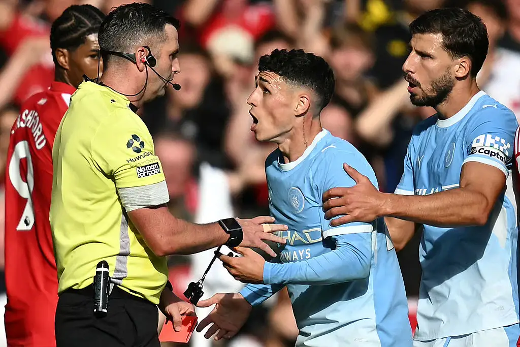 Manchester City's English midfielder #47 Phil Foden (C) reacts to Referee Michael Oliver (L) after being shown a red card during the English Premier League football match between Manchester United and Manchester City at Old Trafford in Manchester, north west England, on September 13, 2026