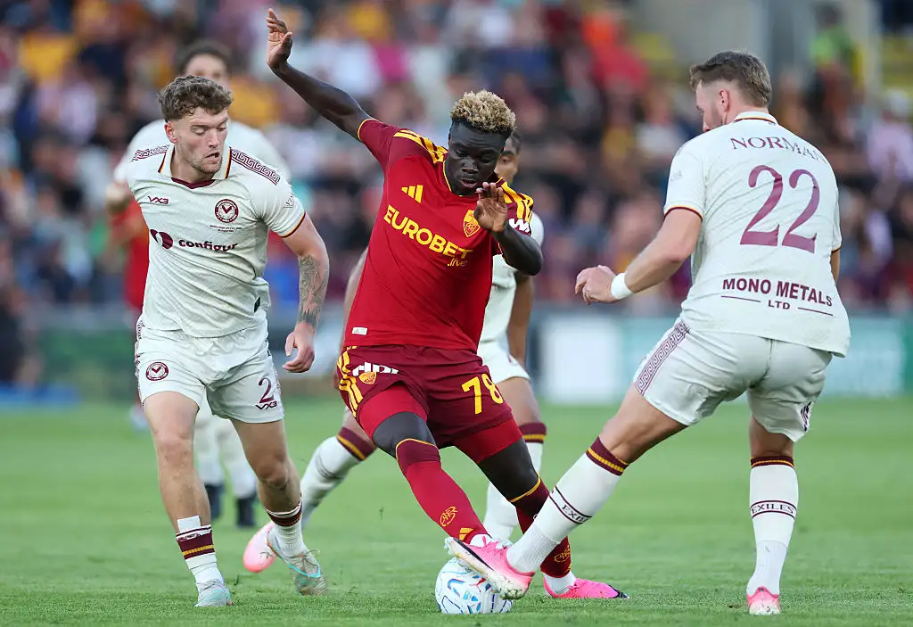 Robinio Vaz of AS Roma runs with the ball under pressure from Cameron Evans and Cameron Norman of Newport County during the pre-season friendly match between Newport County and AS Roma at Rodney Parade on August 04, 2026 in Newport, Wales