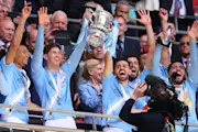 Manchester City's players lift the FA Cup.