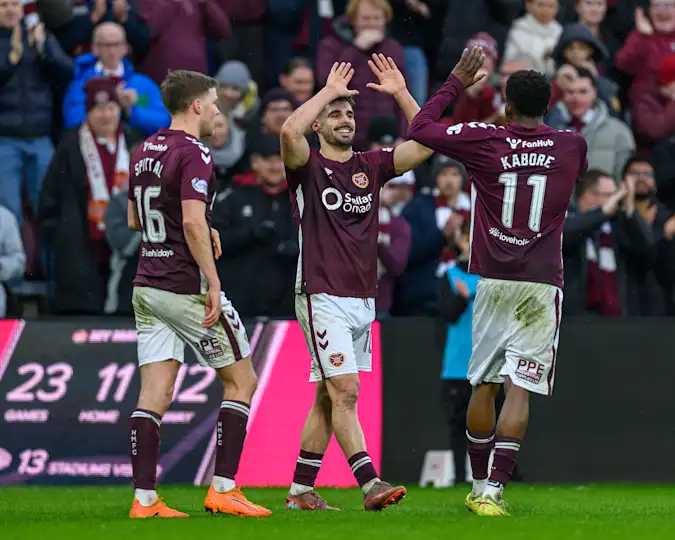 Claudio Braga (Centre) celebrates with Pierre Landry Kabore (R) after he scores the opening goal during the Premier League match between Heart of Midlothian and Aberdeen at Tynecastle Park