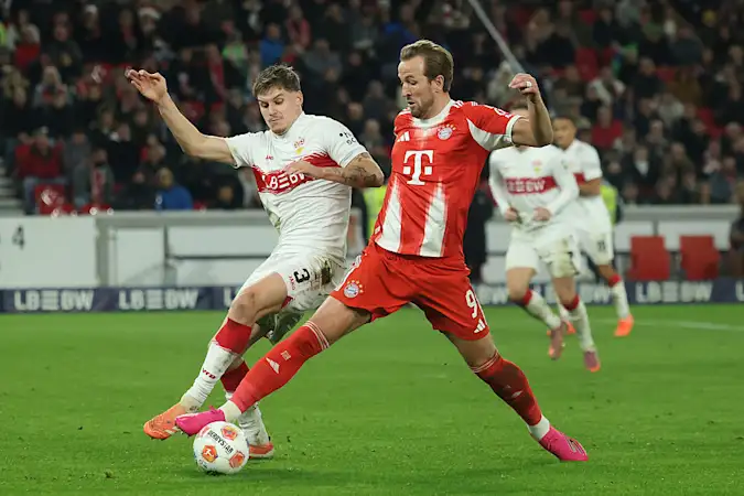 Harry Kane of FC Bayern Munich is challenged by Ramon Hendriks of VfB Stuttgart.
