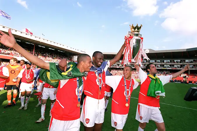 Gilberto, Patrick Vieira, Gael Clichy and Edu of Arsenal with the Premier League trophy after the match between Arsenal and Leicester City in the Premier League at Highbury on May 15, 2004 in London, England. (Photo by Stuart MacFarlane via Getty Images)