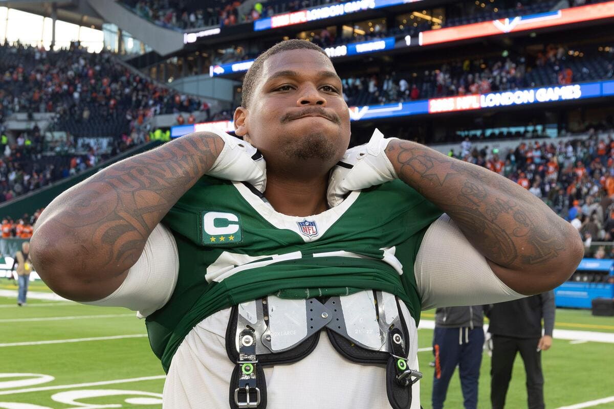 Former New York Jets defensive tackle Quinnen Williams grabs the color of his shoulder pads.